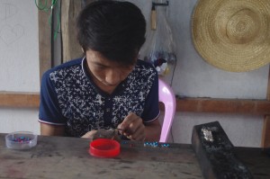 Boy mounting cut glass in silver rings